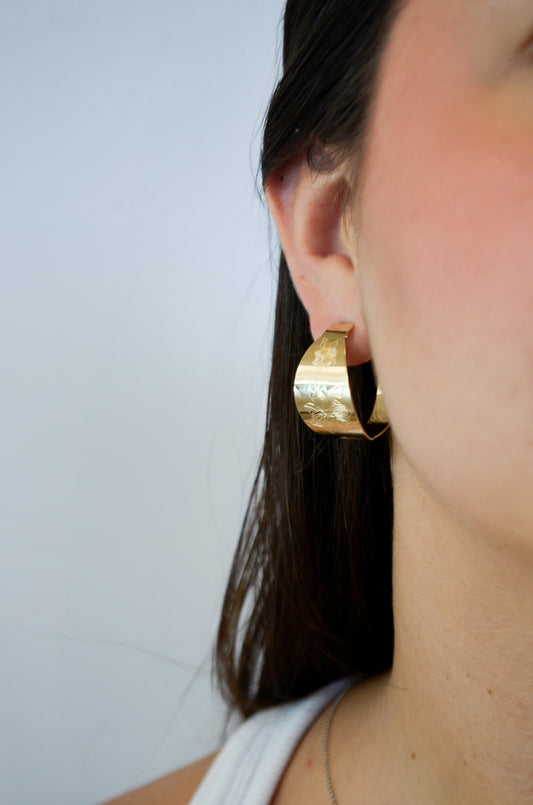 Argola chapa com desenho de flor banhada a ouro 18k - Biju & Cia.